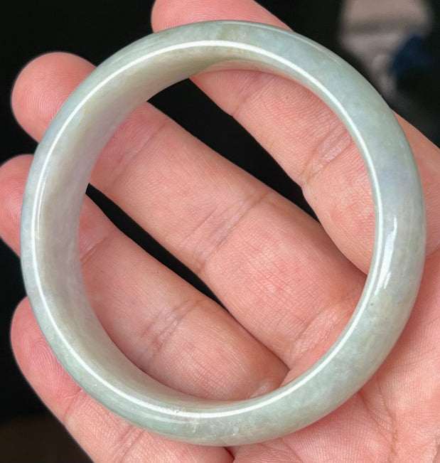 Close-up of fine crystalline texture and greyish hues on icy apple green jadeite bangle