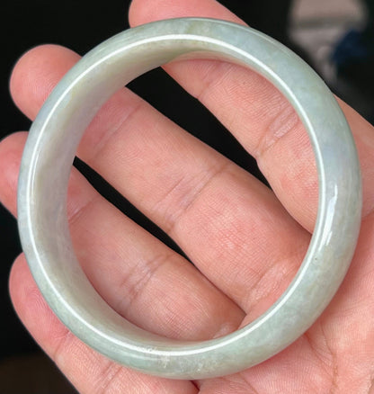 Close-up of fine crystalline texture and greyish hues on icy apple green jadeite bangle