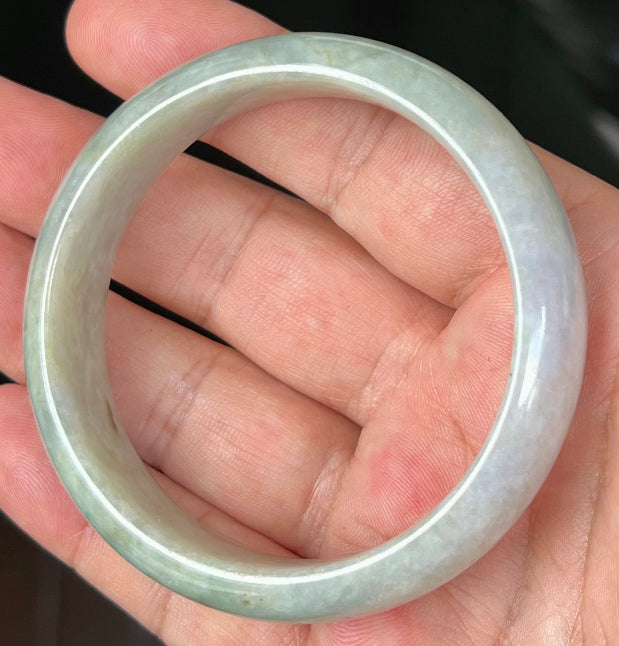 Close-up of fine crystalline texture and greyish hues on icy apple green jadeite bangle