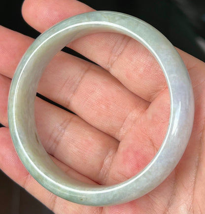 Close-up of fine crystalline texture and greyish hues on icy apple green jadeite bangle