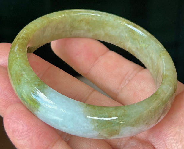 Close-up of fine crystalline texture and honey hues on icy apple green jadeite bangle