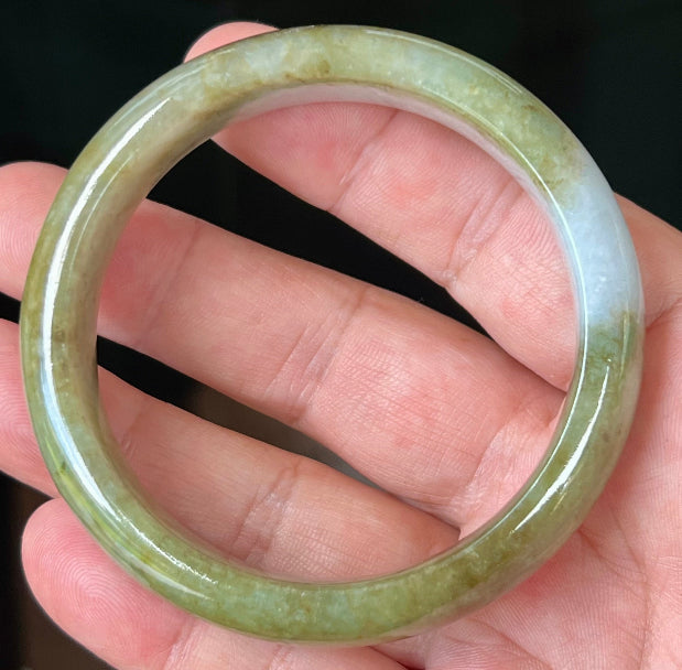 Close-up of fine crystalline texture and honey hues on icy apple green jadeite bangle