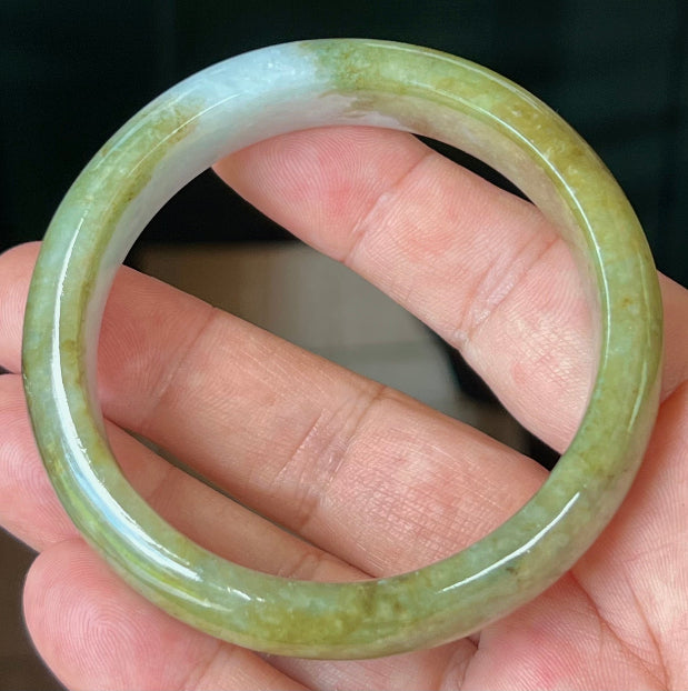 Close-up of fine crystalline texture and honey hues on icy apple green jadeite bangle