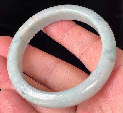 Close-up of fine crystalline texture and soothing green hues on icy milky white jadeite bangle