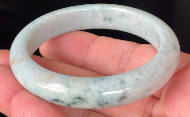 Close-up of fine crystalline texture and soothing green hues on icy milky white jadeite bangle