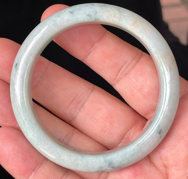Close-up of fine crystalline texture and soothing green hues on icy milky white jadeite bangle