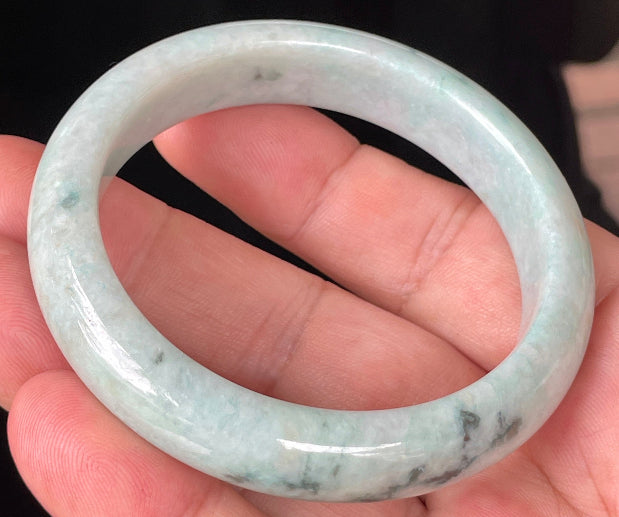 Close-up of fine crystalline texture and soothing green hues on icy milky white jadeite bangle
