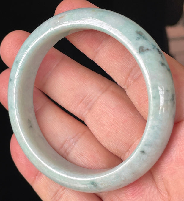 Close-up of fine crystalline texture and soothing green hues on icy milky white jadeite bangle