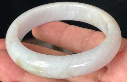 Close-up of fine crystalline texture and delicate honey hues on icy light lavender jadeite bangle