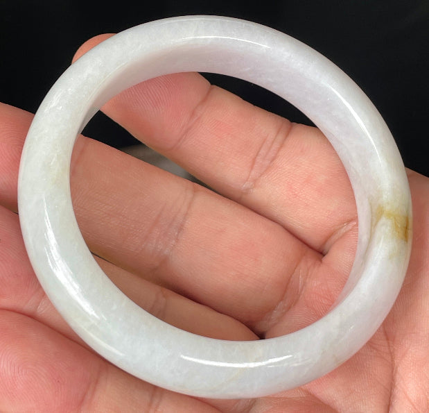 Close-up of fine crystalline texture and delicate honey hues on icy light lavender jadeite bangle