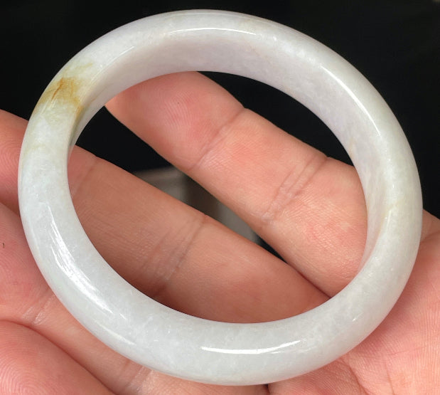 Close-up of fine crystalline texture and delicate honey hues on icy light lavender jadeite bangle