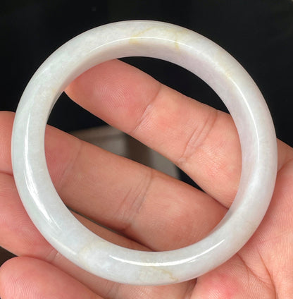 Close-up of fine crystalline texture and delicate honey hues on icy light lavender jadeite bangle