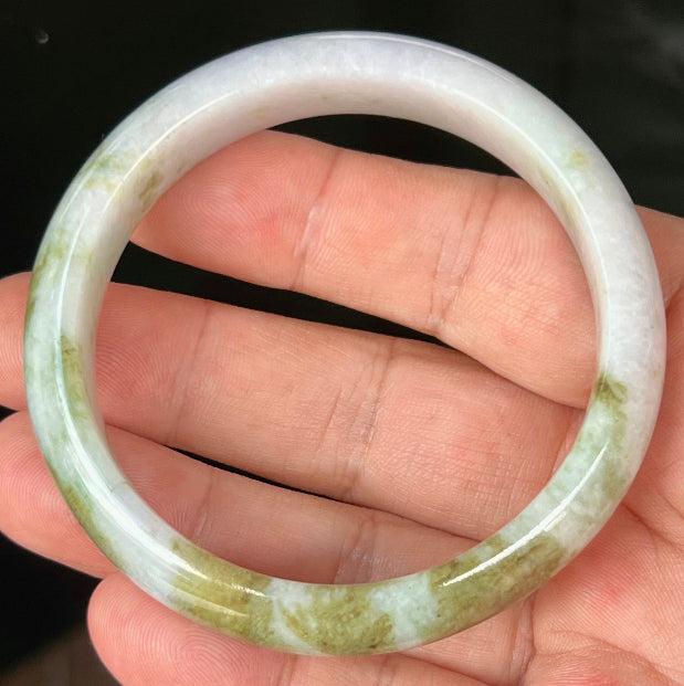 Close-up of fine crystalline texture and light brown hues on icy milky white jadeite bangle