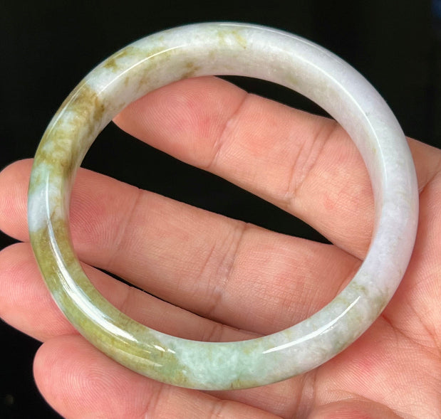 Close-up of fine crystalline texture and light brown hues on icy milky white jadeite bangle