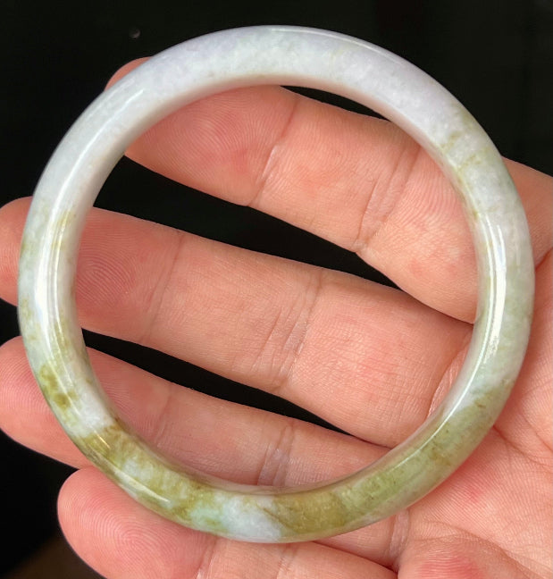 Close-up of fine crystalline texture and light brown hues on icy milky white jadeite bangle