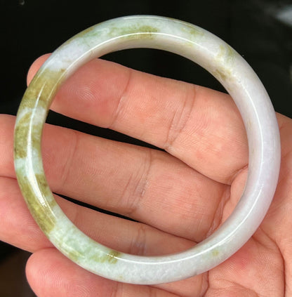 Close-up of fine crystalline texture and light brown hues on icy milky white jadeite bangle