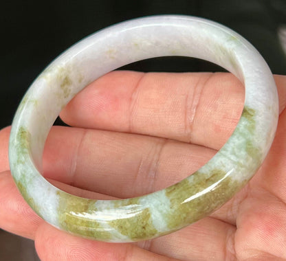 Close-up of fine crystalline texture and light brown hues on icy milky white jadeite bangle