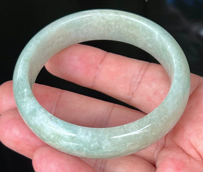 Close-up of fine crystalline texture and milky white hues on icy light apple green jadeite bangle