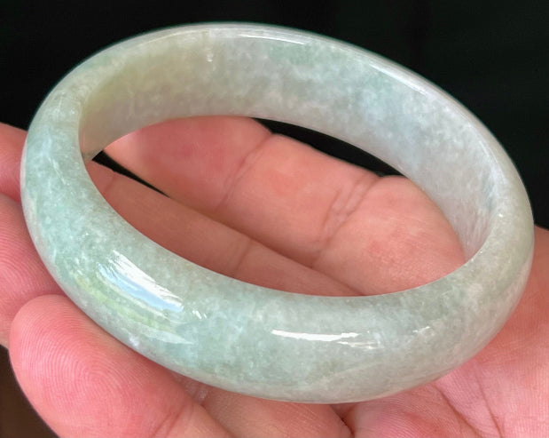 Close-up of fine crystalline texture and milky white hues on icy apple green jadeite bangle