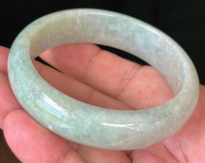 Close-up of fine crystalline texture and milky white hues on icy apple green jadeite bangle