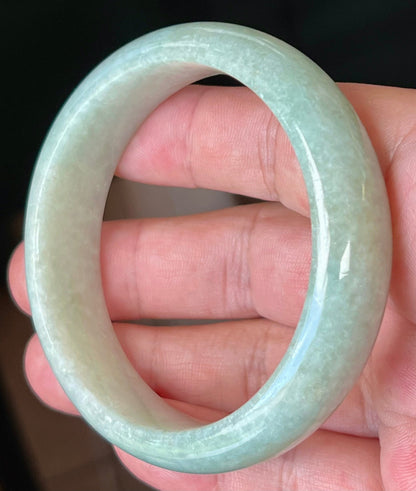 Close-up of fine crystalline texture and milky white hues on icy apple green jadeite bangle
