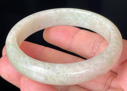 Close-up of fine crystalline texture and light imperial green hues on icy honey and white jadeite bangle