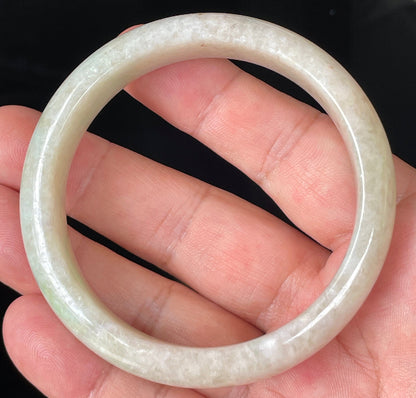 Close-up of fine crystalline texture and light imperial green hues on icy honey and white jadeite bangle
