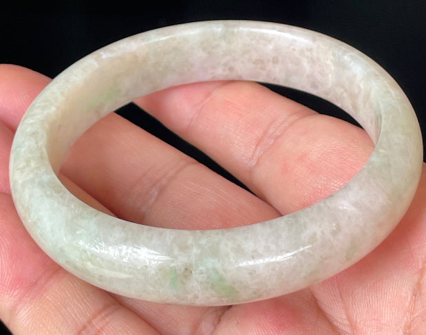 Close-up of fine crystalline texture and light imperial green hues on icy honey and white jadeite bangle