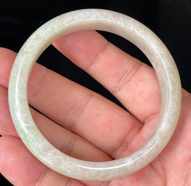 Close-up of fine crystalline texture and light imperial green hues on icy honey and white jadeite bangle