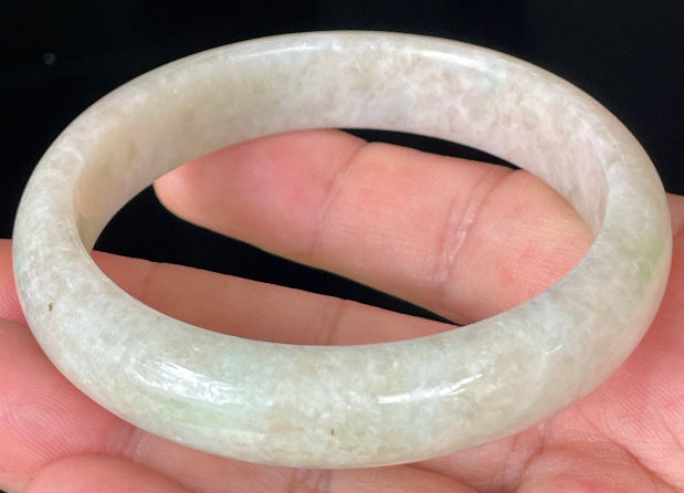 Close-up of fine crystalline texture and light imperial green hues on icy honey and white jadeite bangle