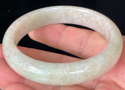 Close-up of fine crystalline texture and light imperial green hues on icy honey and white jadeite bangle