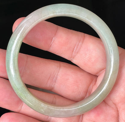 Close-up of fine crystalline texture and vibrant apple green hues on milky white jadeite bangle