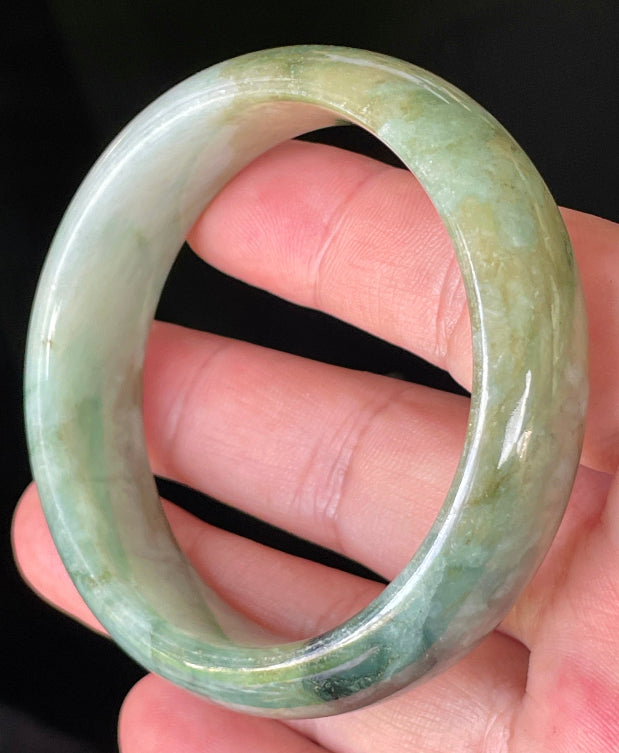 Close-up of fine crystalline texture and natural jade veins on icy bluish apple green jadeite bangle