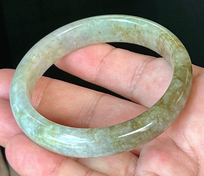 Close-up of fine crystalline texture and golden honey hues on icy grayish white jadeite bangle
