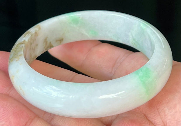 Close-up of fine crystalline texture and imperial green veins on icy milky white jadeite bangle