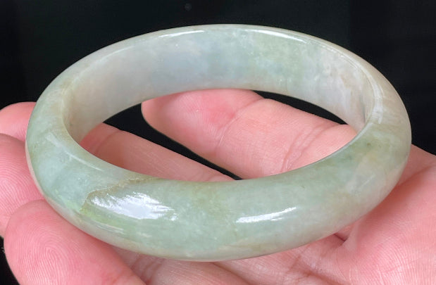Close-up of fine crystalline texture and moss-in-the-snow effect on icy apple green jadeite bangle