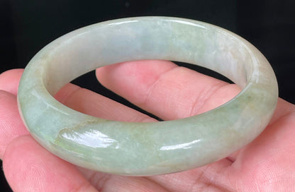 Close-up of fine crystalline texture and moss-in-the-snow effect on icy apple green jadeite bangle