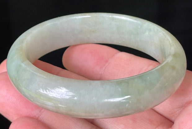 Close-up of fine crystalline texture and moss-in-the-snow effect on icy apple green jadeite bangle