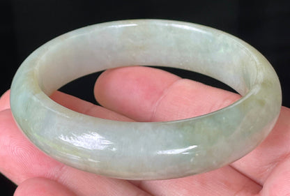 Close-up of fine crystalline texture and moss-in-the-snow effect on icy apple green jadeite bangle