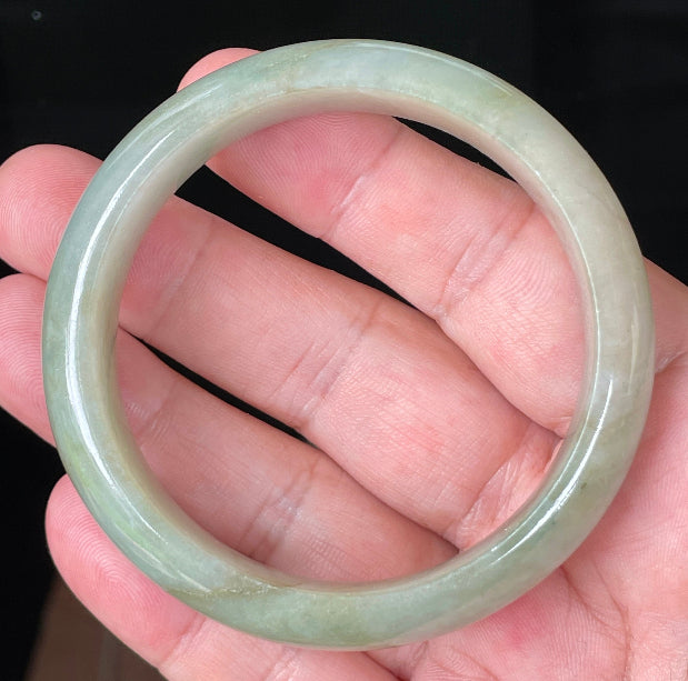 Close-up of fine crystalline texture and moss-in-the-snow effect on icy apple green jadeite bangle