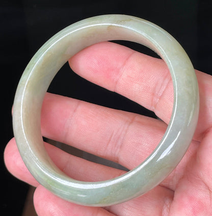 Close-up of fine crystalline texture and moss-in-the-snow effect on icy apple green jadeite bangle