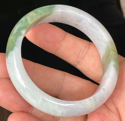 Close-up of fine crystalline texture and moss in the snow pattern on icy greyish white jadeite bangle
