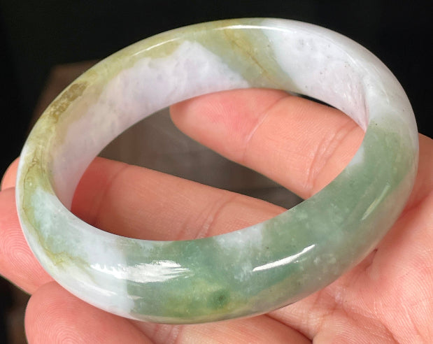 Close-up of fine crystalline texture and moss in the snow pattern on icy greyish white jadeite bangle