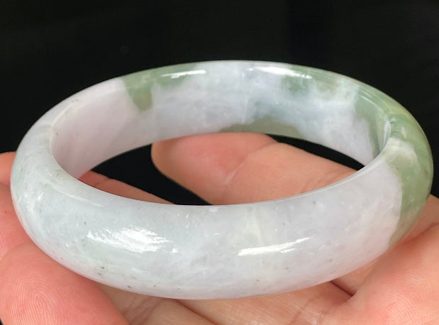 Close-up of fine crystalline texture and moss in the snow pattern on icy greyish white jadeite bangle