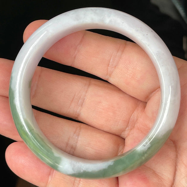 Close-up of fine crystalline texture and moss in the snow pattern on icy greyish white jadeite bangle