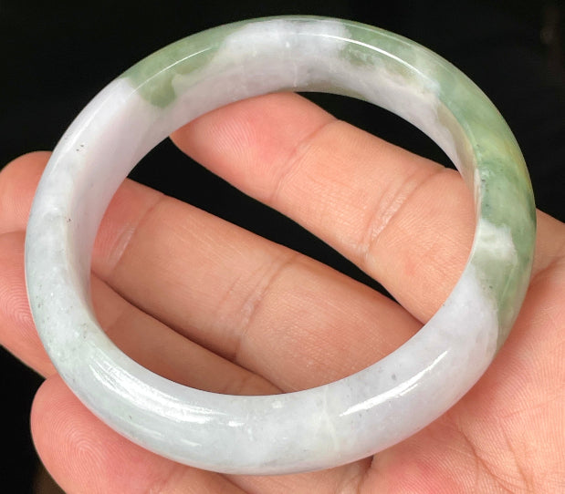 Close-up of fine crystalline texture and moss in the snow pattern on icy greyish white jadeite bangle