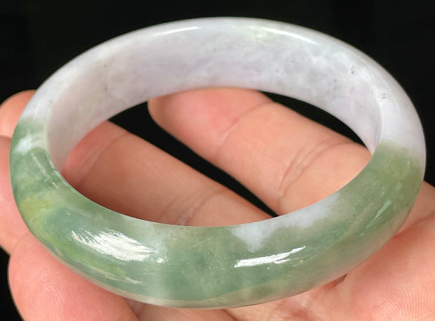 Close-up of fine crystalline texture and moss in the snow pattern on icy greyish white jadeite bangle