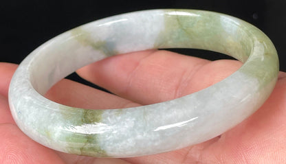 Close-up of fine crystalline texture and moss in the snow effect on icy greyish white jadeite bangle