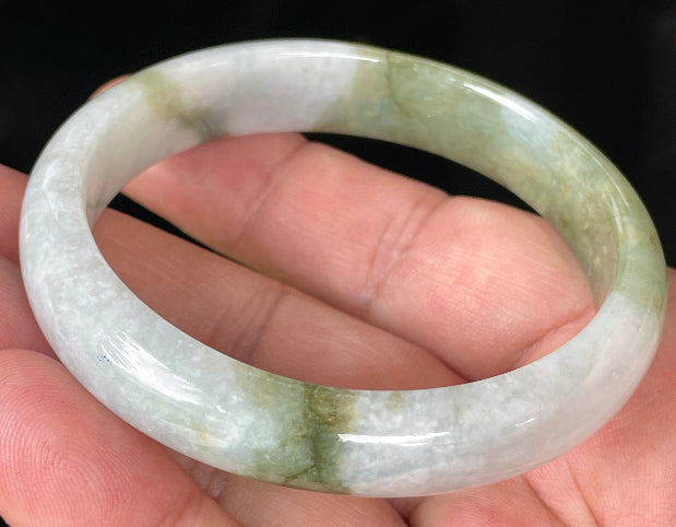 Close-up of fine crystalline texture and moss in the snow effect on icy greyish white jadeite bangle