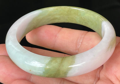 Close-up of fine crystalline texture and rich forest green tones on icy apple green jadeite bangle